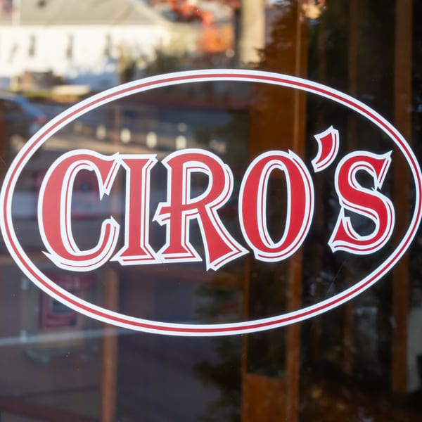 Ciro's Italian restaurant logo, red text with white outline, on a glass door.